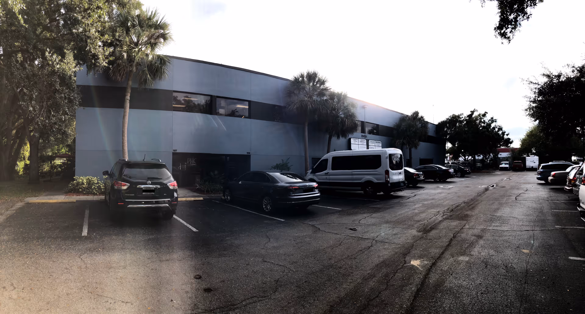 Parking lot in front of Providence Home Care of Florida building with palm trees.