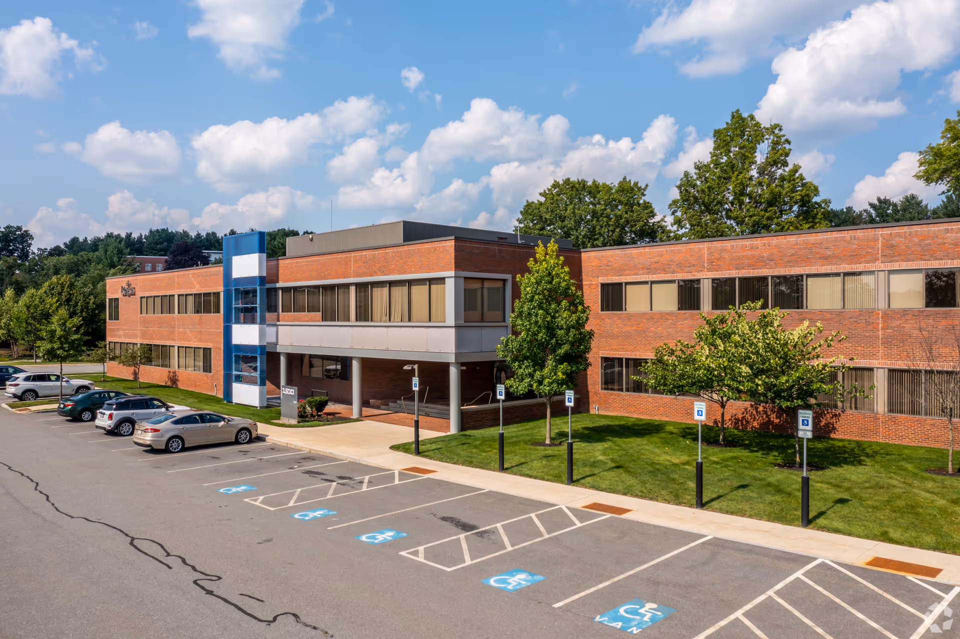 Two-story brick senior living facility exterior with a parking lot.