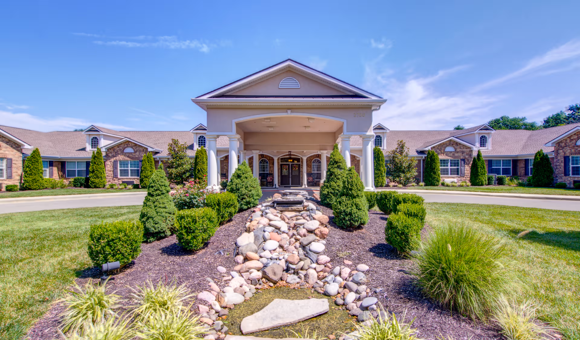 Front view of Addington Place of Prairie Village with landscaped entrance and stone path.