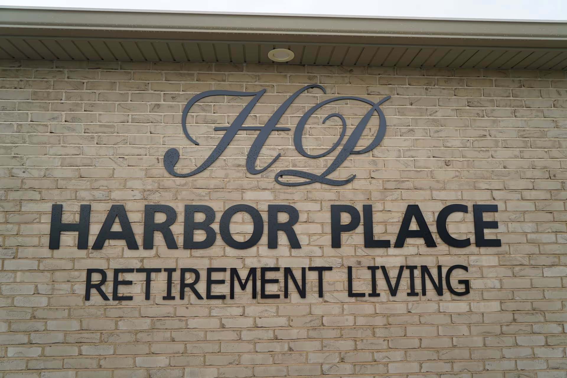 Brick building exterior with Harbor Place Retirement Living sign.