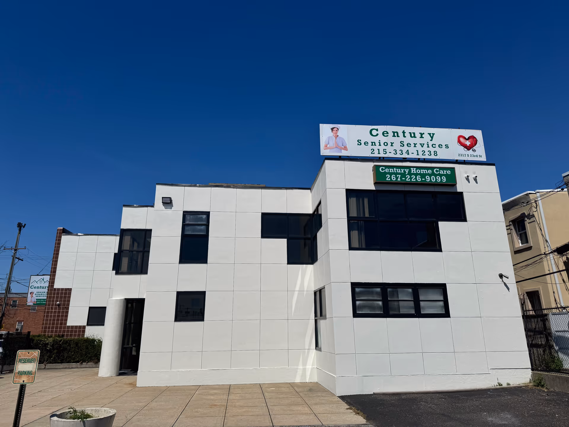 White modern building with Century Senior Services and Century Home Care signs against a blue sky