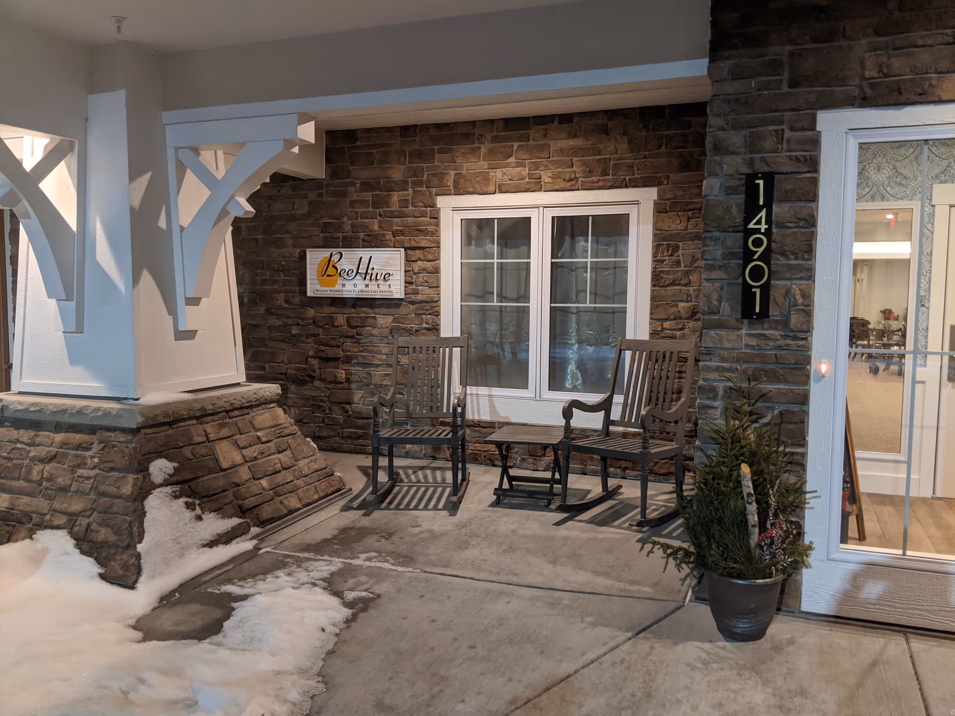Bee Hive Homes Maple Grove exterior entrance with two rocking chairs on a covered porch