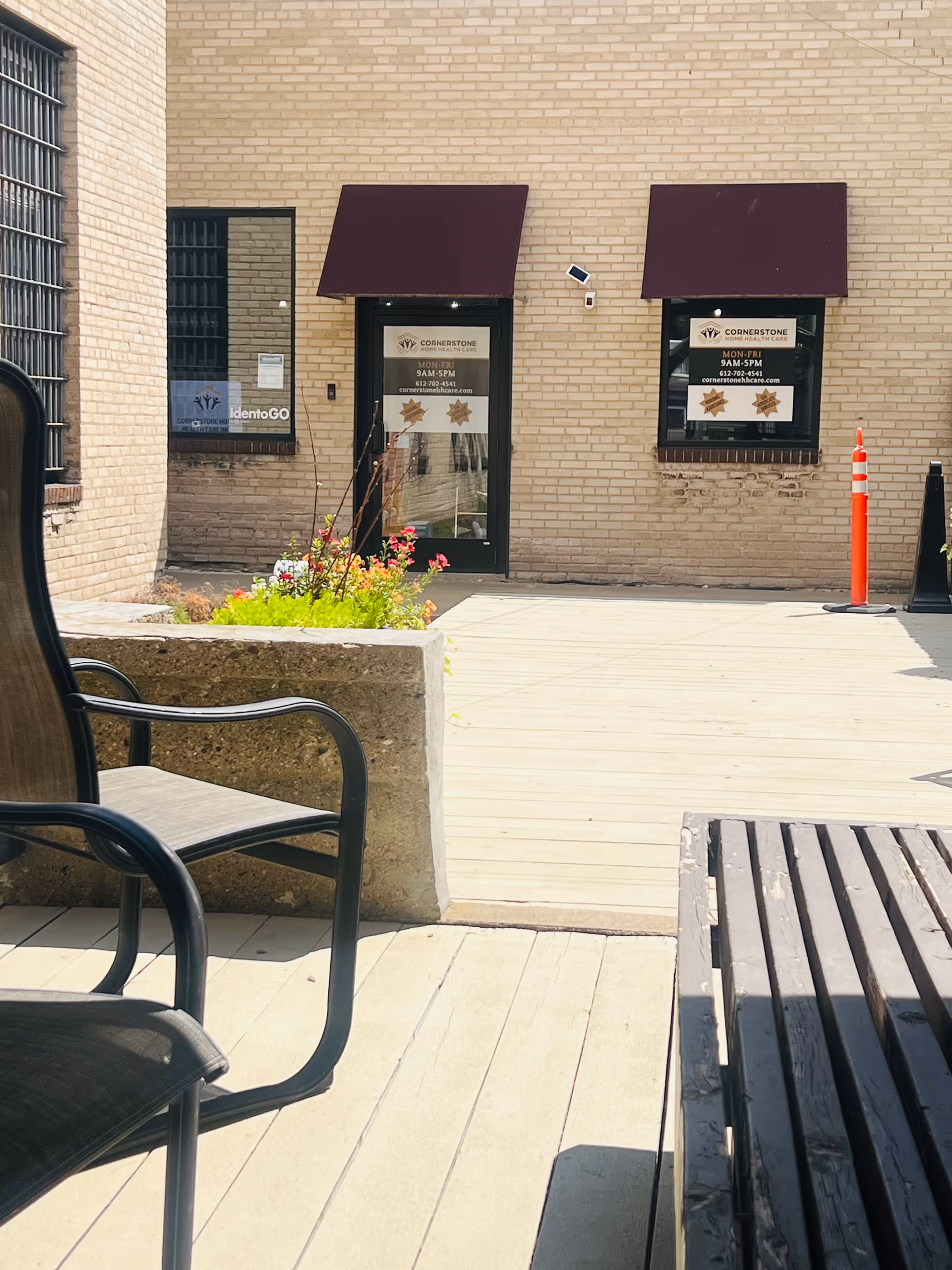 Exterior view of Cornerstone Home Health Care entrance with awnings, benches, and planters.