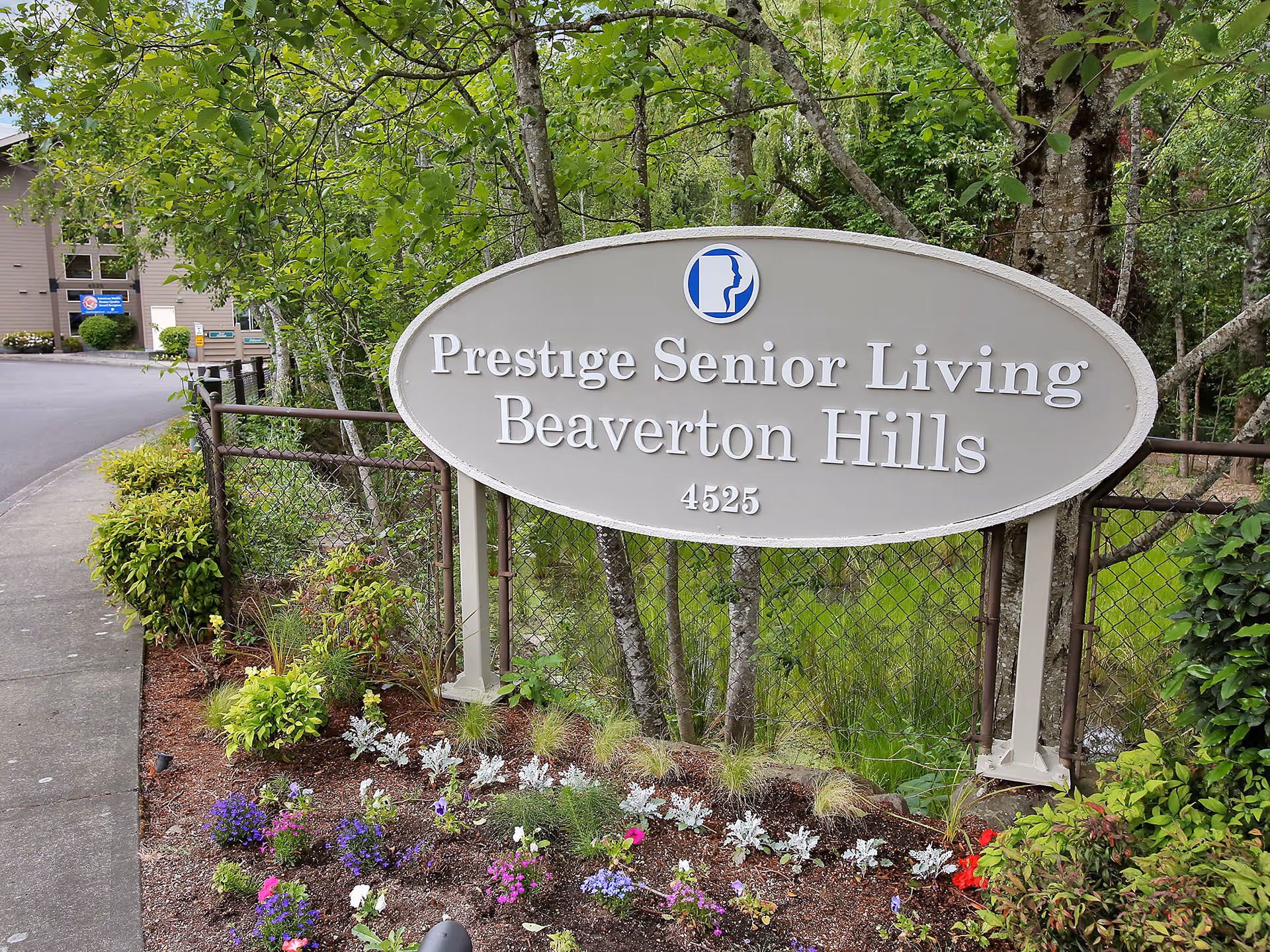 Exterior sign for Prestige Senior Living Beaverton Hills with landscaping.