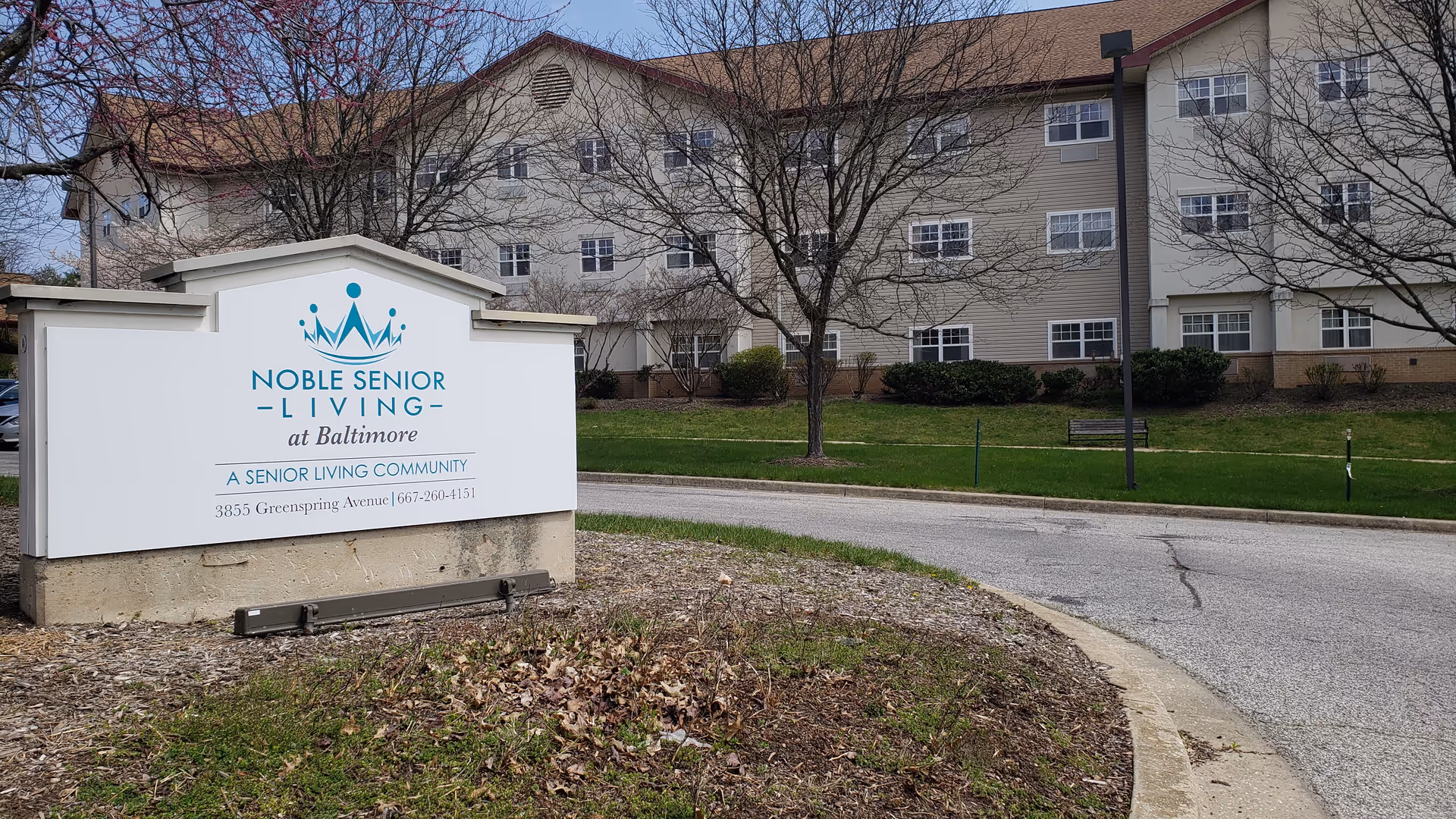 Exterior view of Noble Senior Living at Baltimore with a large front sign and building.