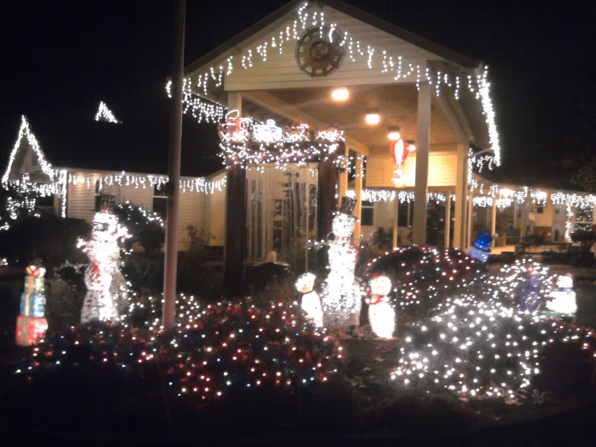 Night view of Meadows Courtyard exterior with festive holiday lights and illuminated snowmen.