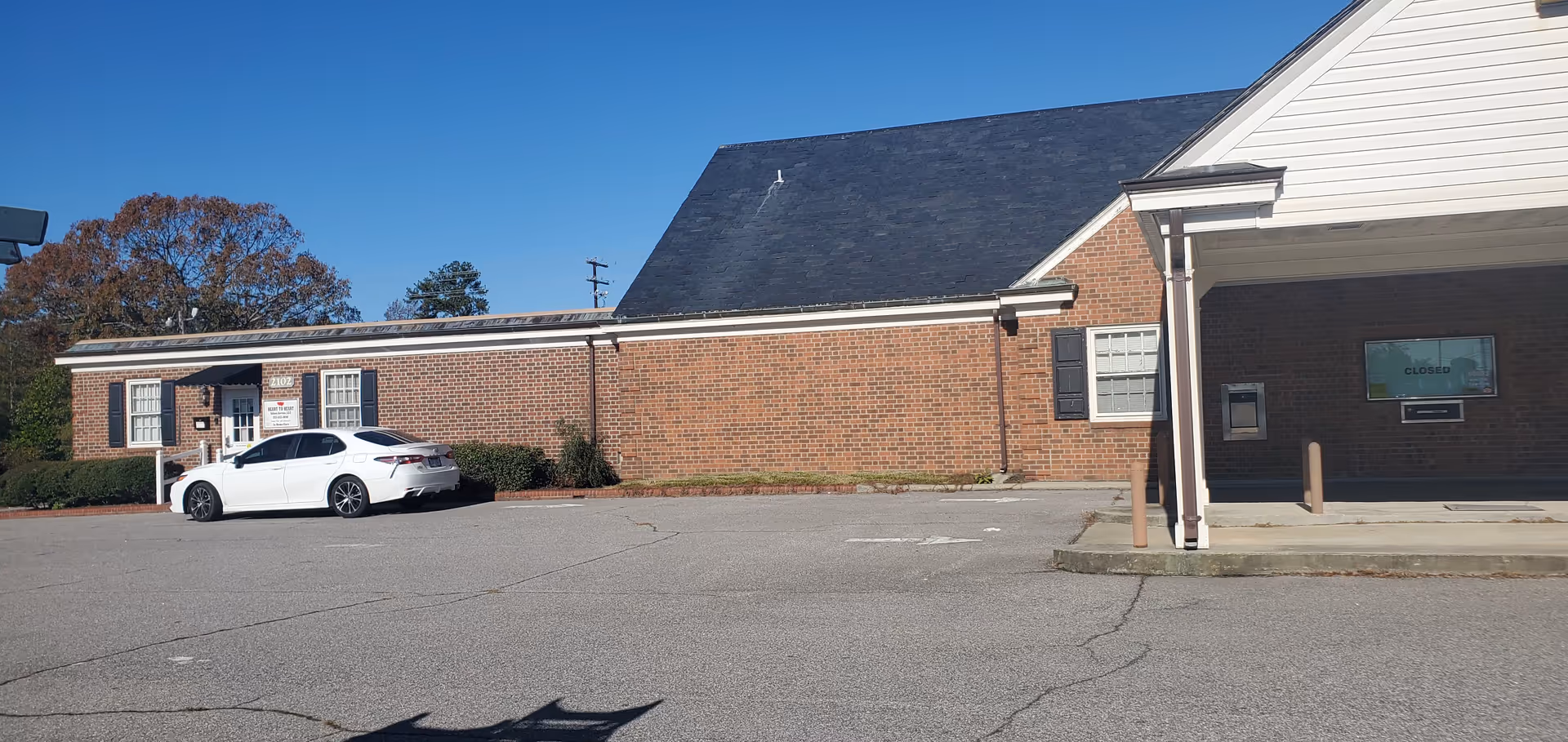 Brick single-story senior care facility exterior with a white car parked in the lot.
