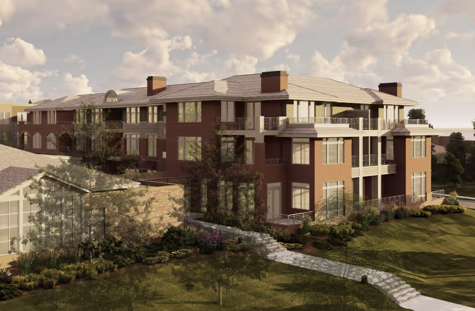 Exterior view of a multi-story brick senior living building with balconies and landscaped grounds under a cloudy sky.