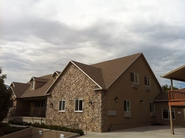 Exterior view of Beacon Heights Senior Living building with stone facade and sloped roof.