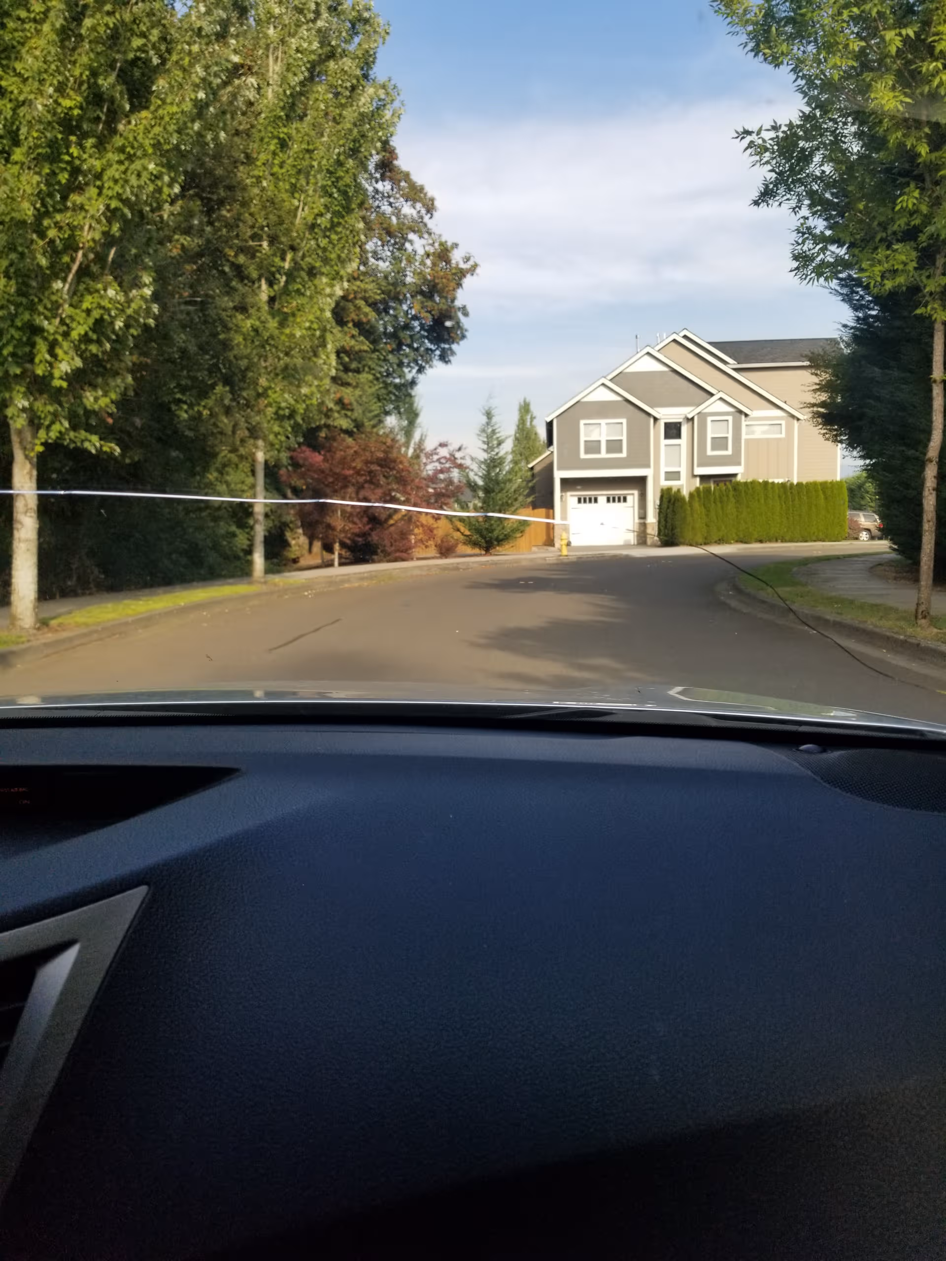 Driver's view of Columbia Ridge Senior Living exterior across a tree-lined street.