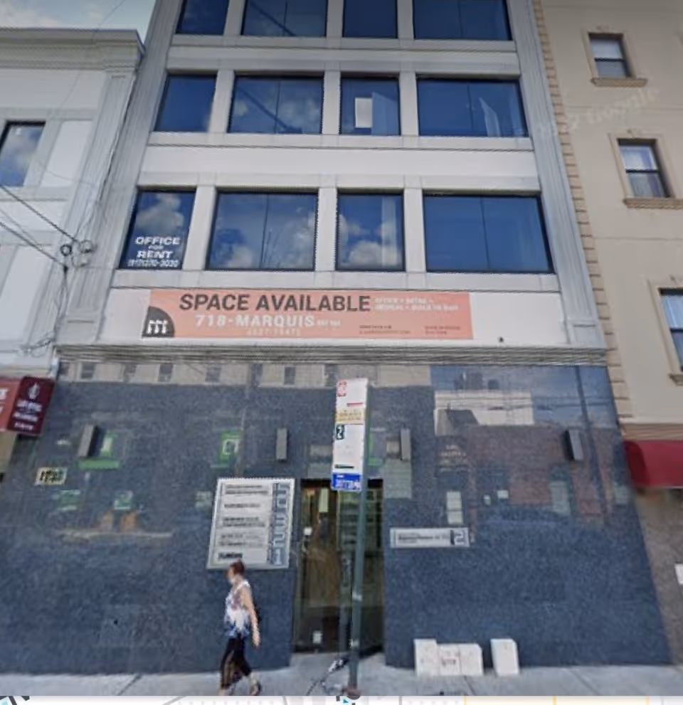 Facade of a multi-story building with a large 'SPACE AVAILABLE' banner and a passerby.