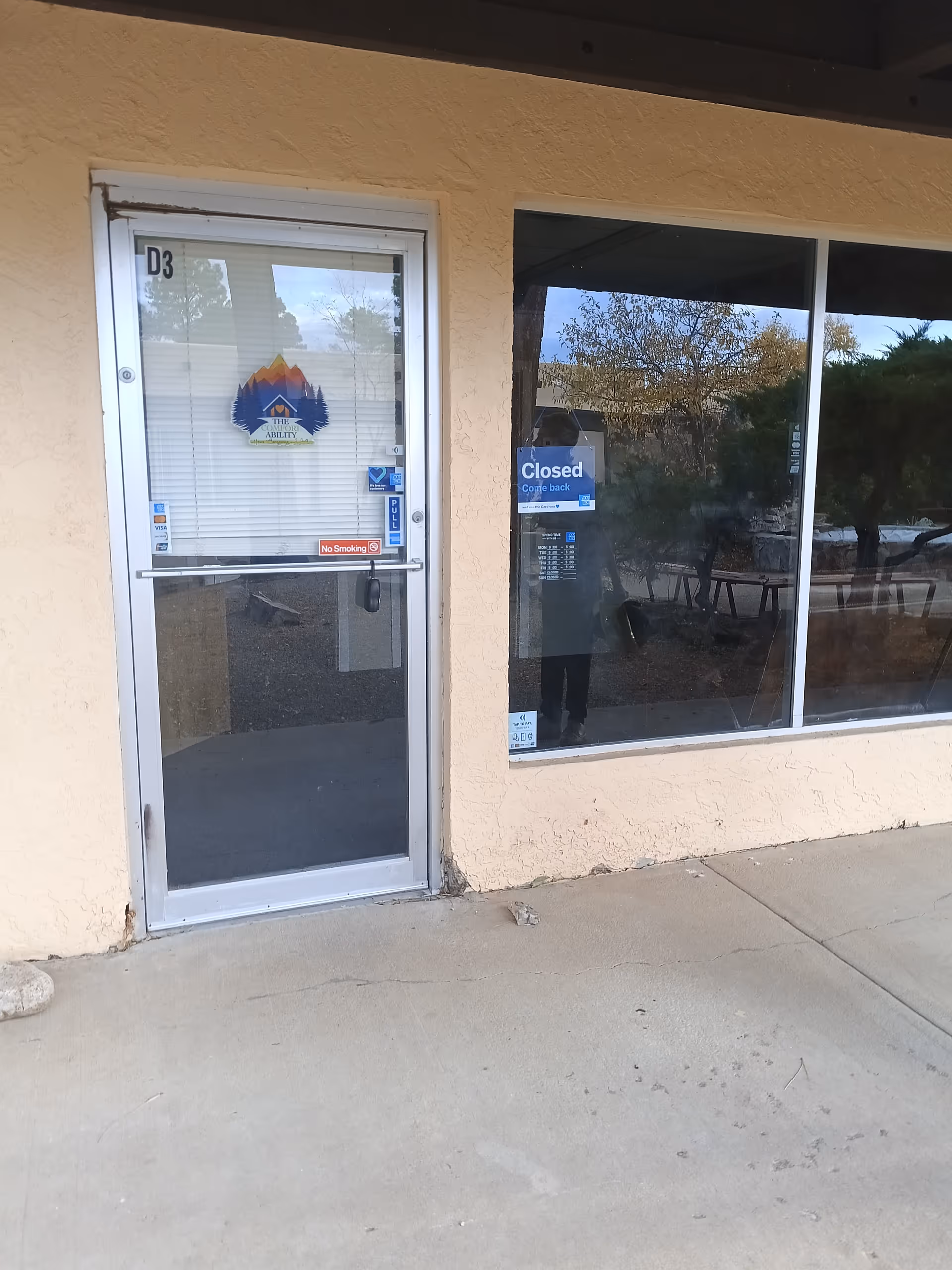 Exterior view of The Comfort Ability Home Caregiving entrance with closed sign on glass door.