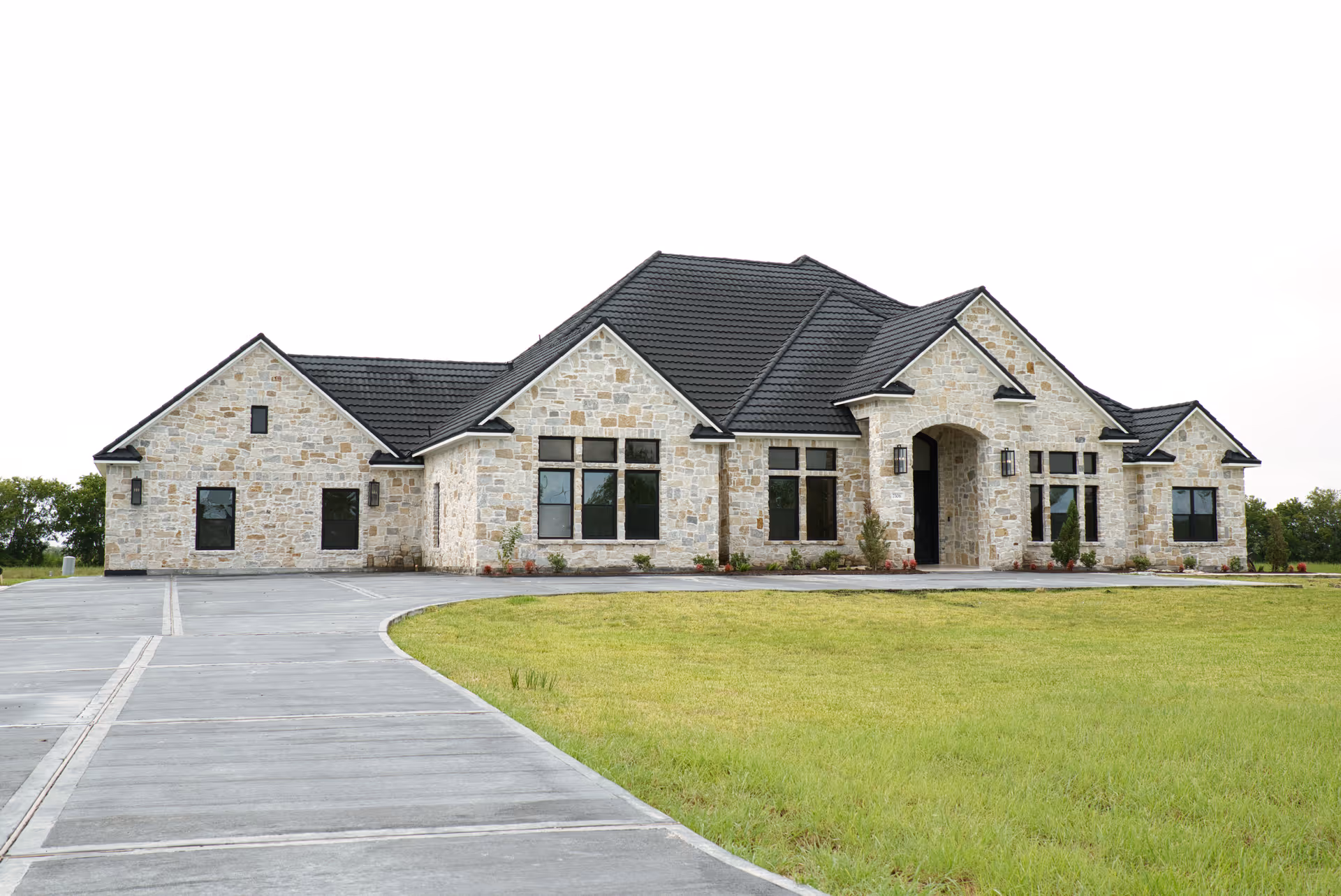 Stone-clad senior living facility front view with curved driveway and green lawn