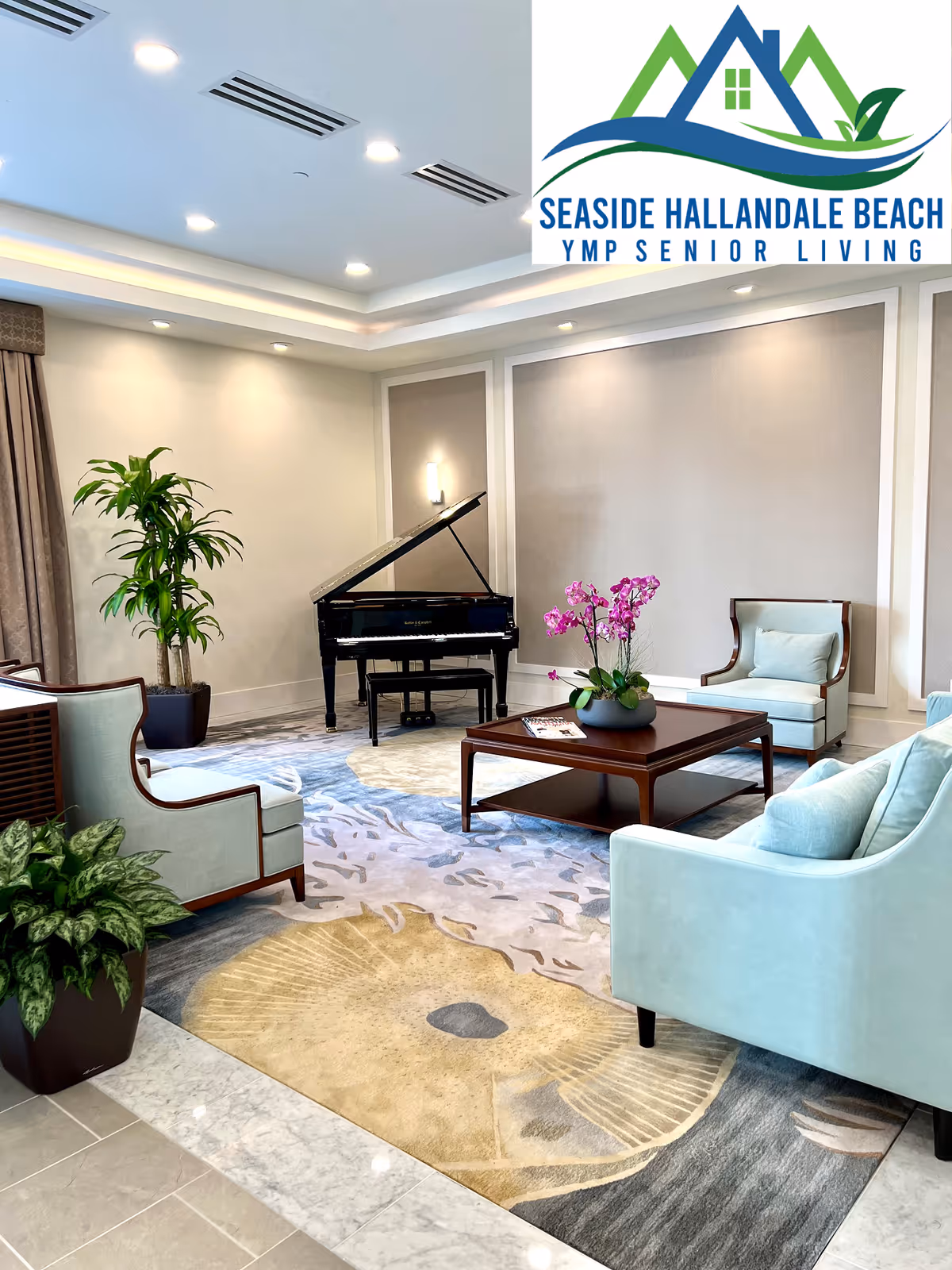 A bright lounge area with a grand piano, mint-colored armchairs, a coffee table, potted plants and a patterned rug.
