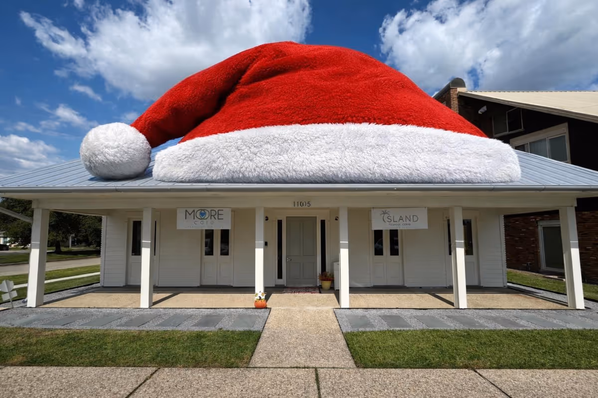 Exterior of Moore Care Caregiver Services building with an oversized Santa hat perched on the roof.