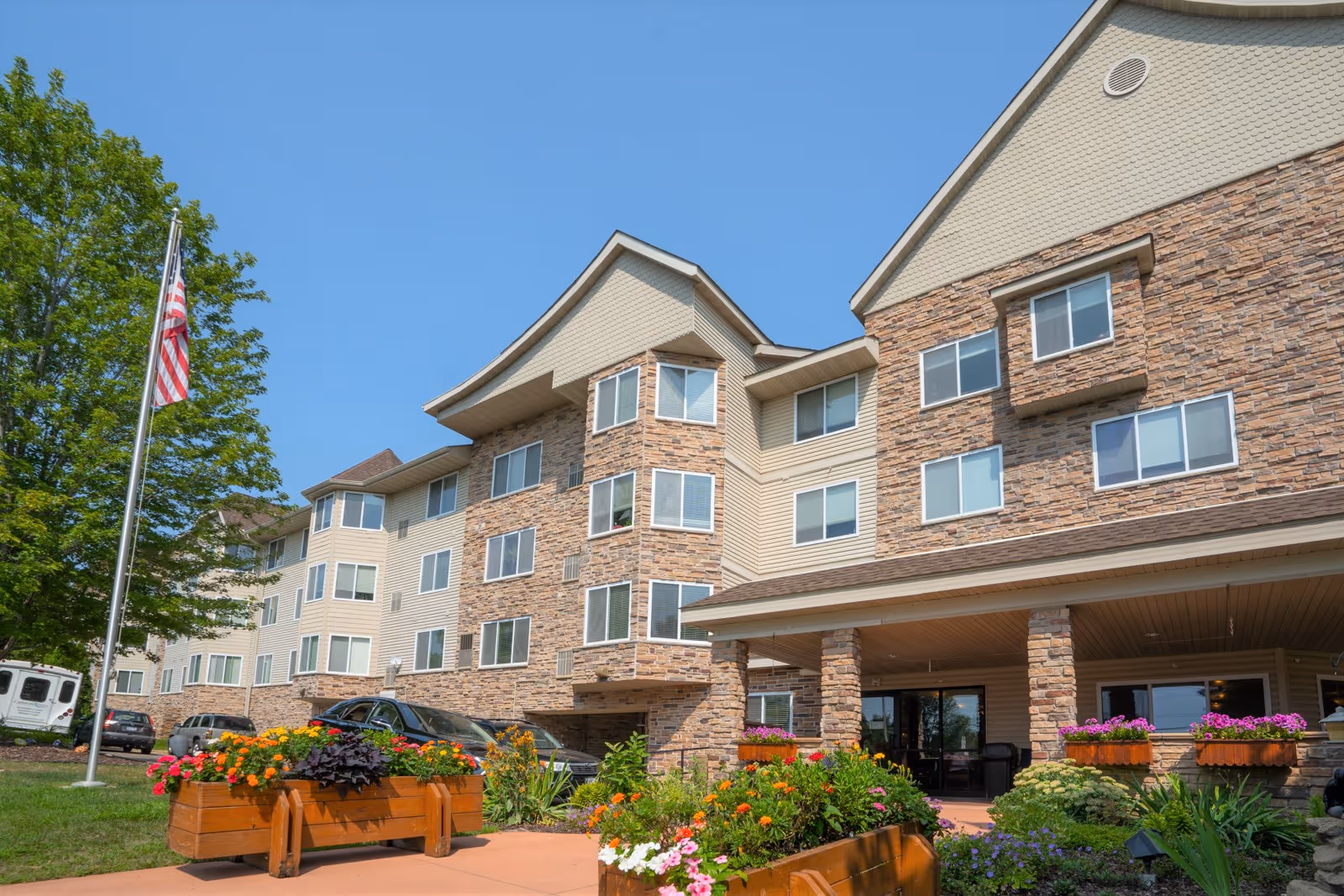 Exterior view of Cannon Rivers Senior Living building with stone facade and landscaped entry.