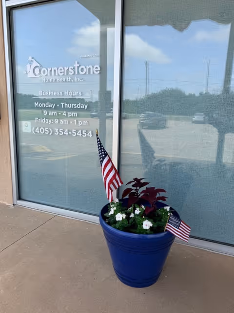 Front entrance of Cornerstone Home Health with a blue planter and flags.