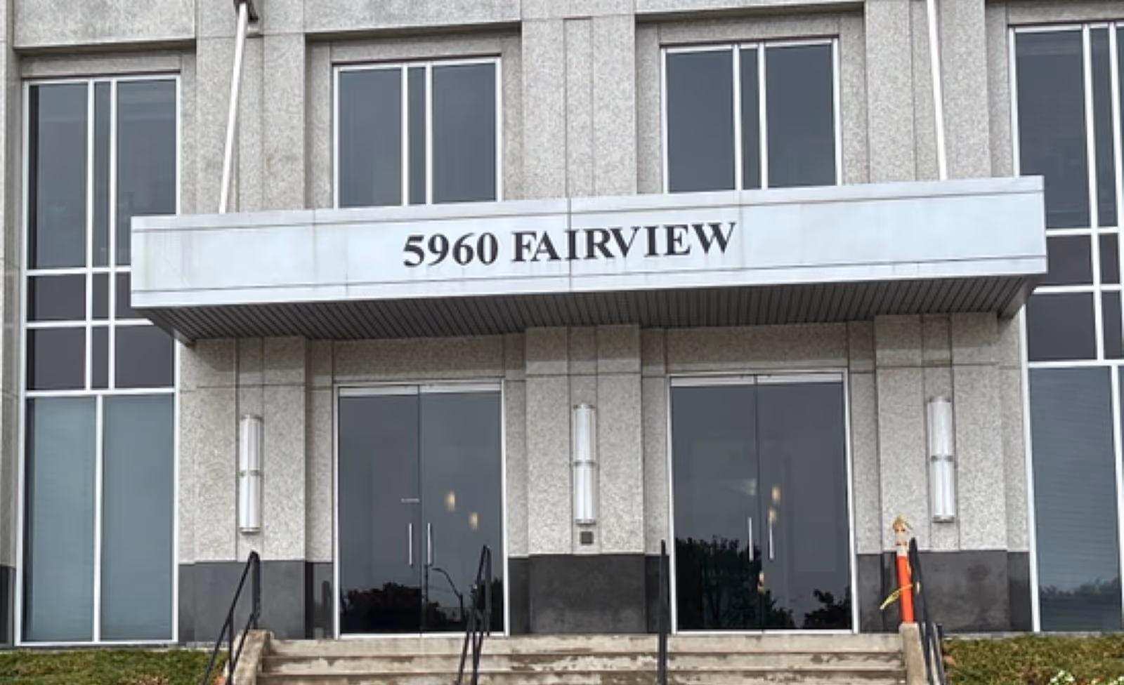 Front view of a gray building entrance with glass doors and 5960 Fairview.