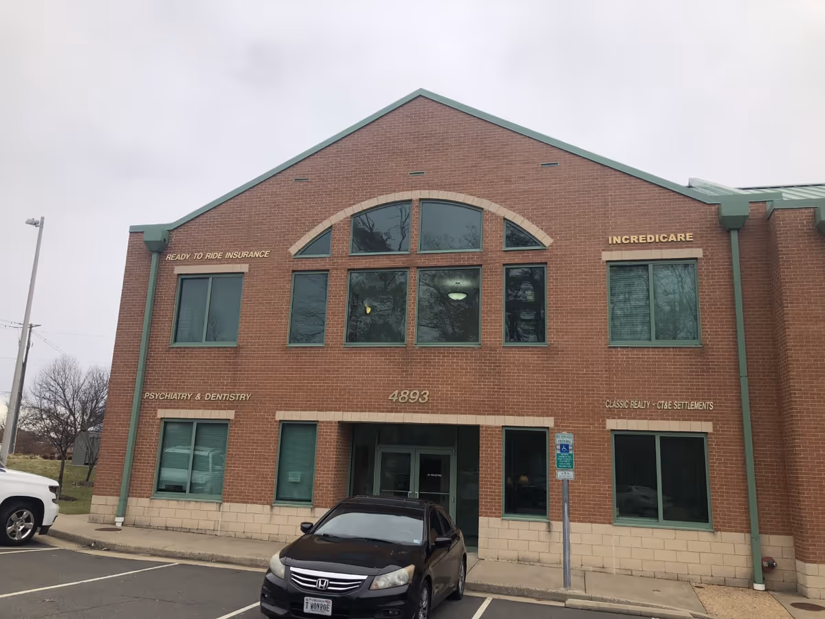Brick commercial building with large arched windows and IncrediCare sign on the front