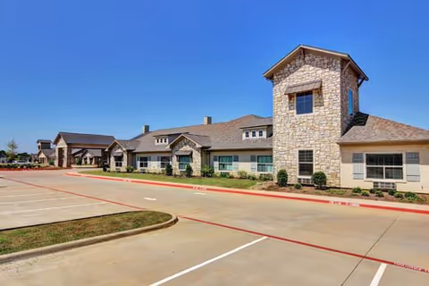 Exterior view of Arabella of Athens Senior Living building with a parking lot.