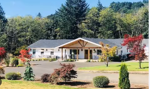 Front view of Aveena Memory Care facility with entrance, trees, and landscaped lawn.