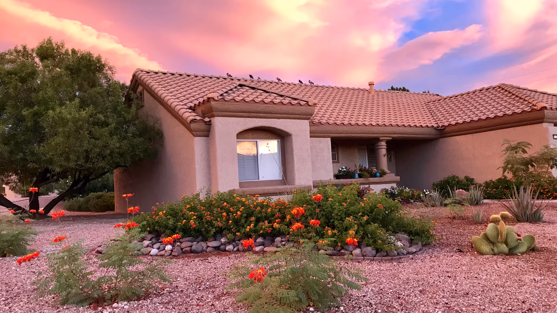 Sun City Summerlin facility exterior features desert landscaping and a tiled roof at sunset.