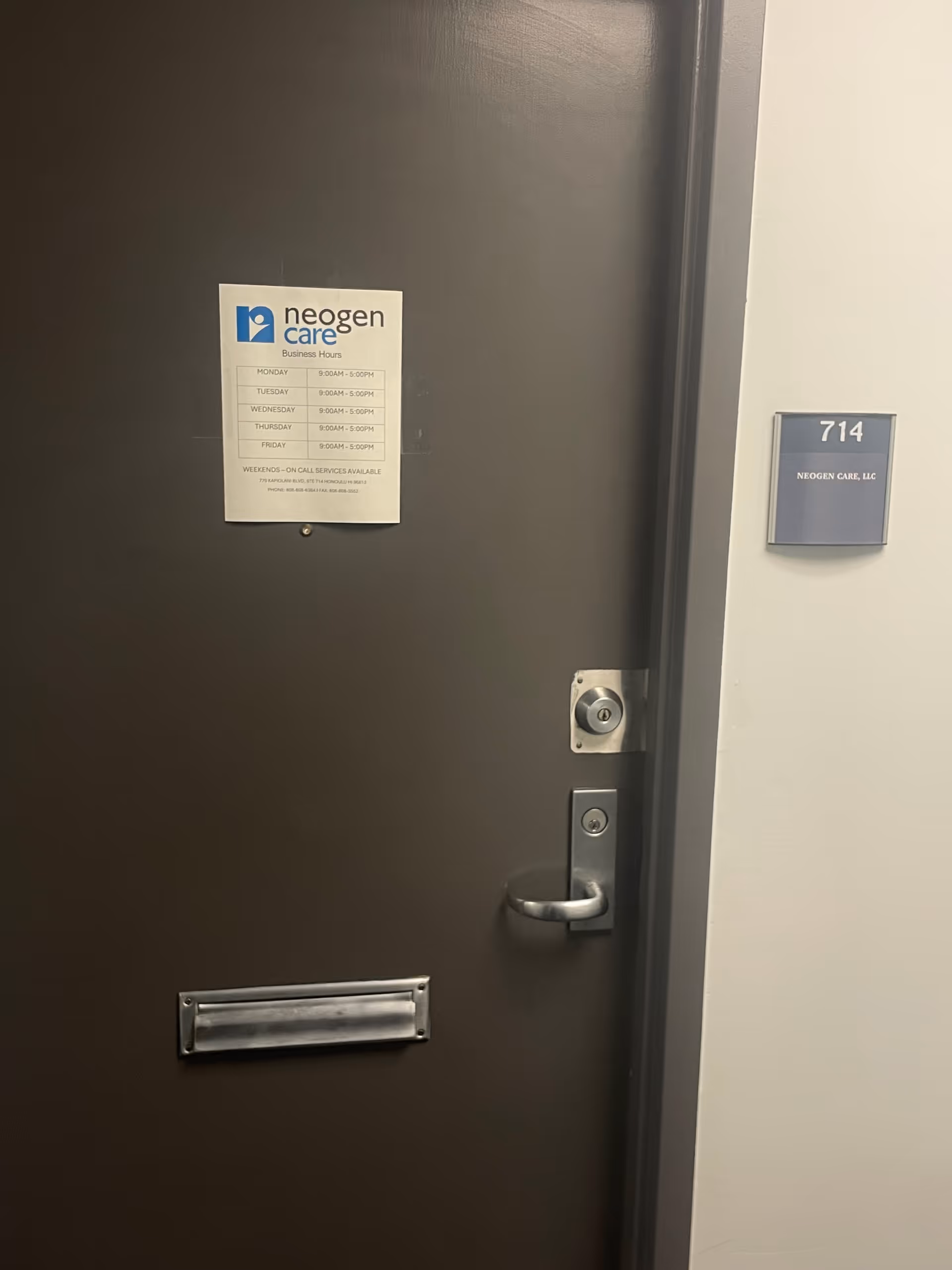 Dark metal door with Neogen Care sign and unit number 714 on the wall
