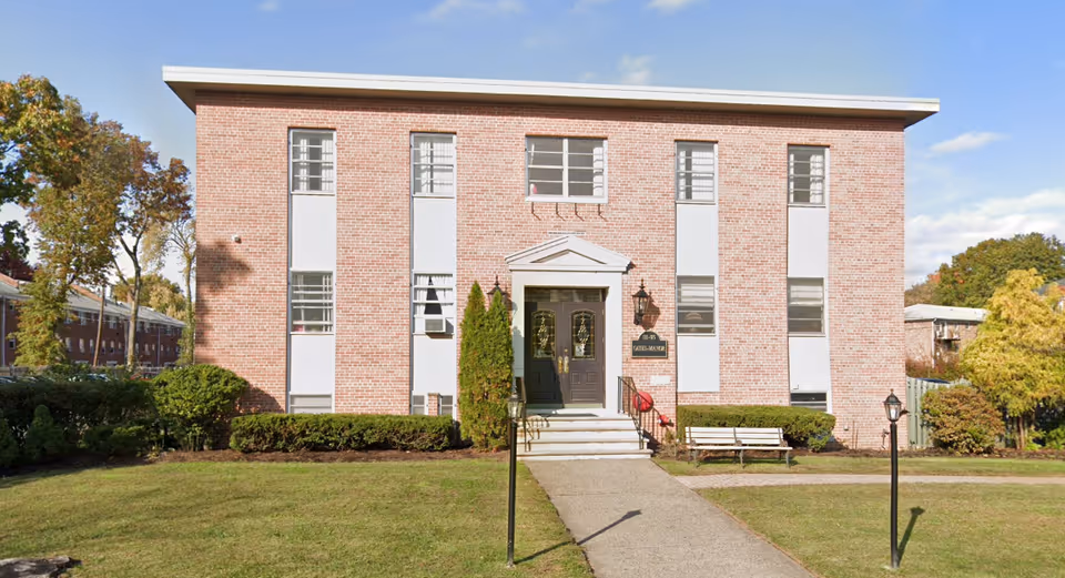 Brick Montclair Care Center building front with steps, doors, windows, and lawn