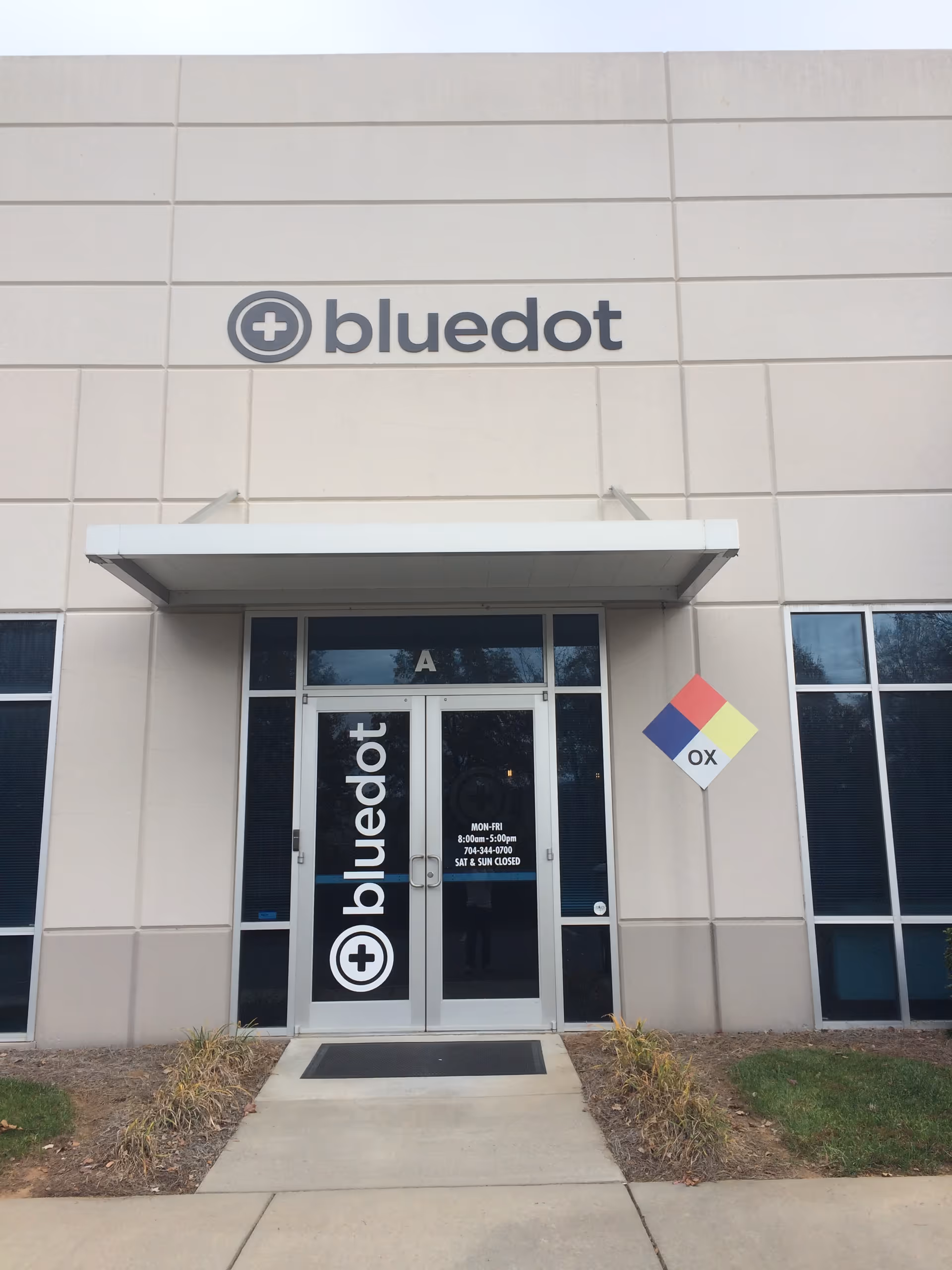 Exterior entrance of BlueDot facility with glass doors and logo.
