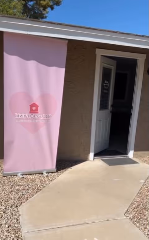 Exterior view of a facility entrance with a pink banner reading Liviys Cares