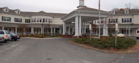 Exterior view of The Cottage at Litchfield Hills showing the entrance and parked cars.