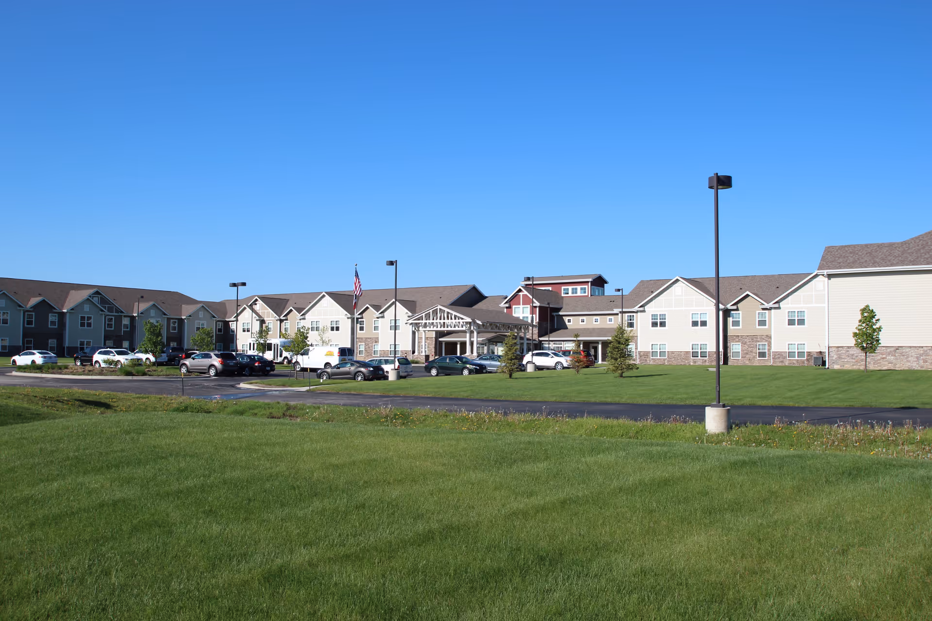 Exterior view of Kennybrook Village senior living campus with lawn and parking.