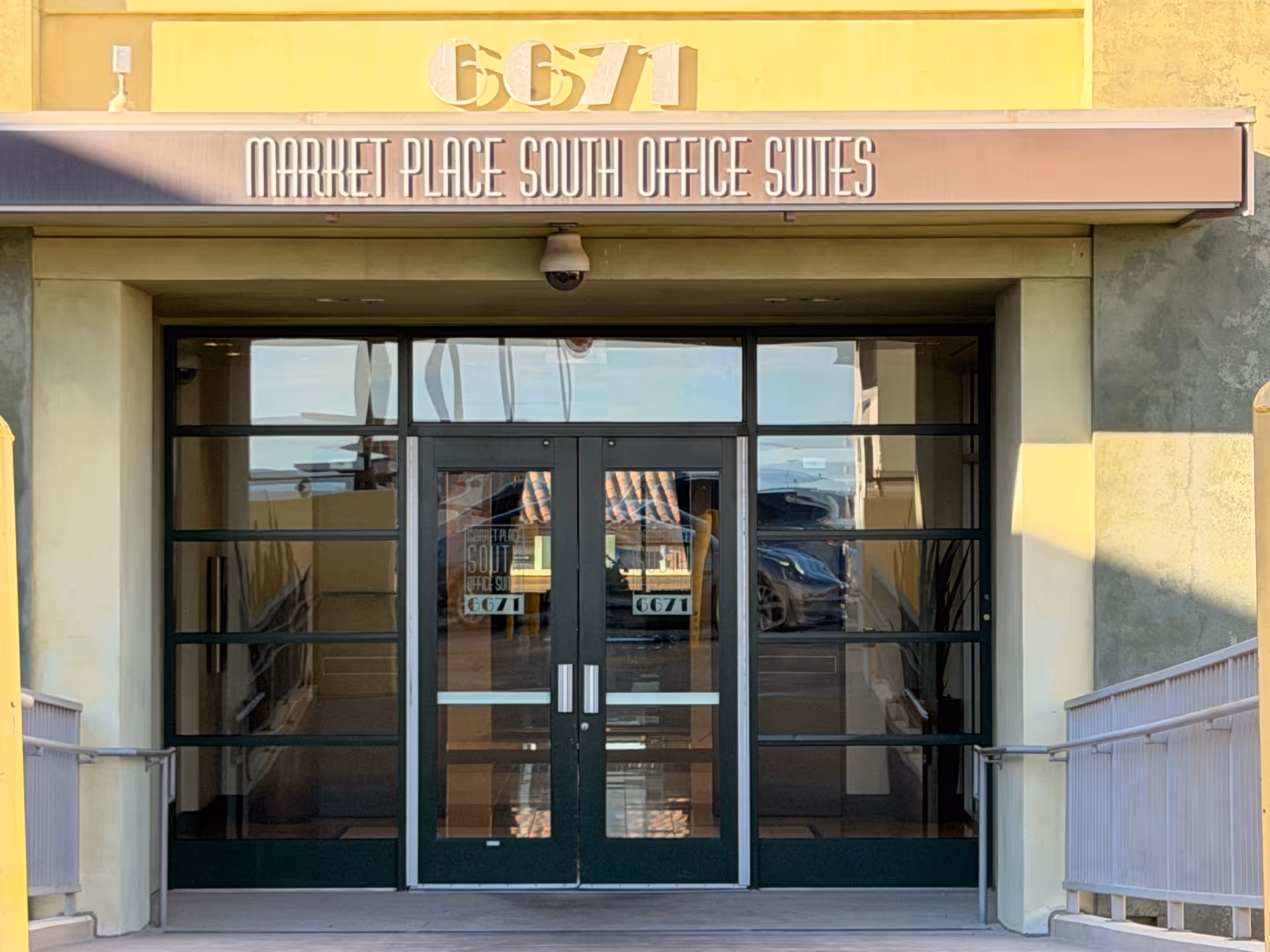 Front entrance of a building with glass doors labeled Market Place South Office Suites