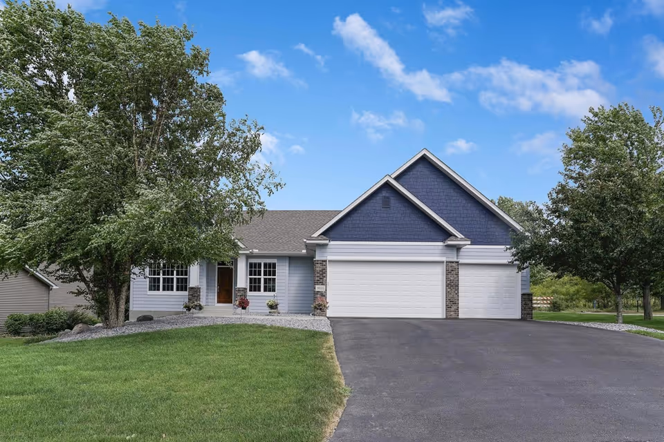 Front view of a single-story home with a three-car garage and green lawn.