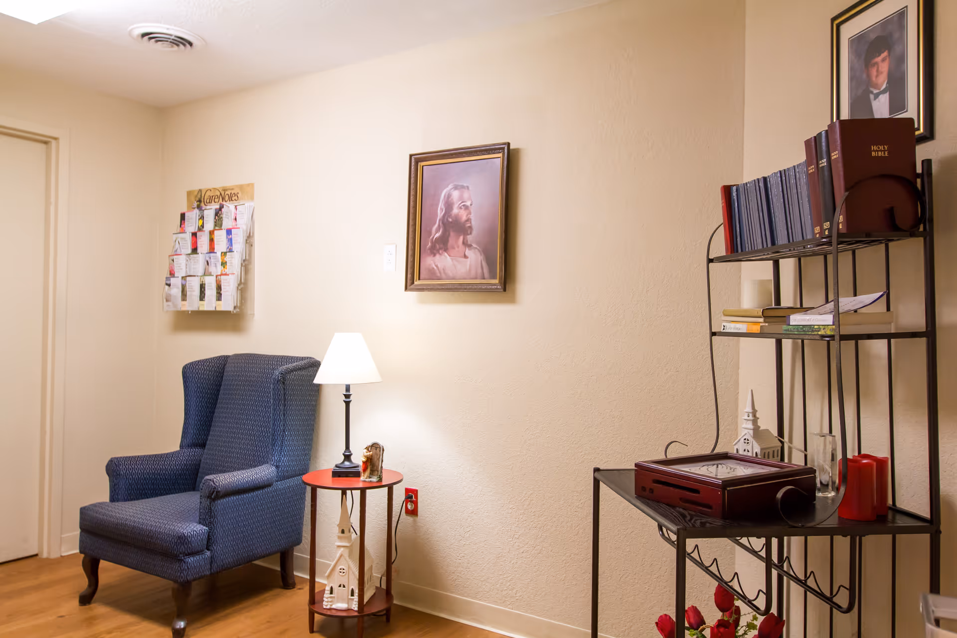 Blue armchair with lamp beside a round side table in a cozy living room corner.