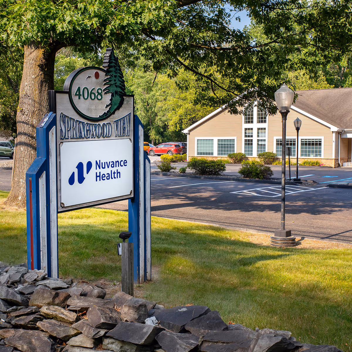 Exterior view of a Nuvance Health sign and clinic building in a parking lot.