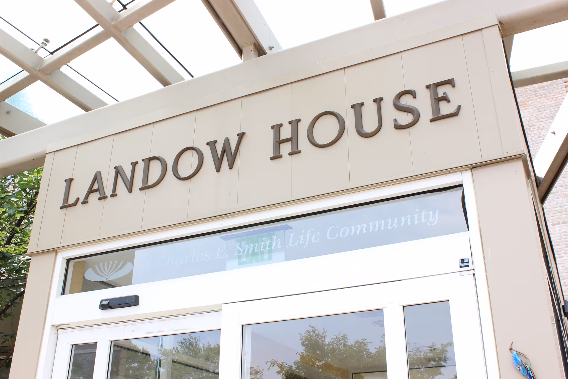 Exterior entrance of Landow House senior living facility with a large sign above doors.