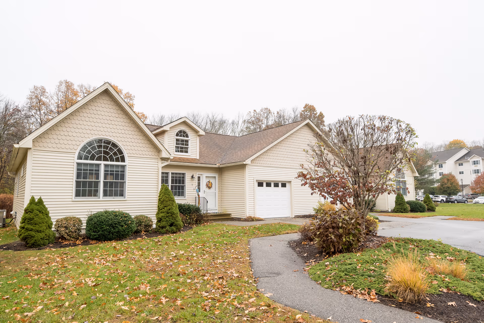 Creamery Brook Village front exterior showing arched window, garage, and landscaped lawn.
