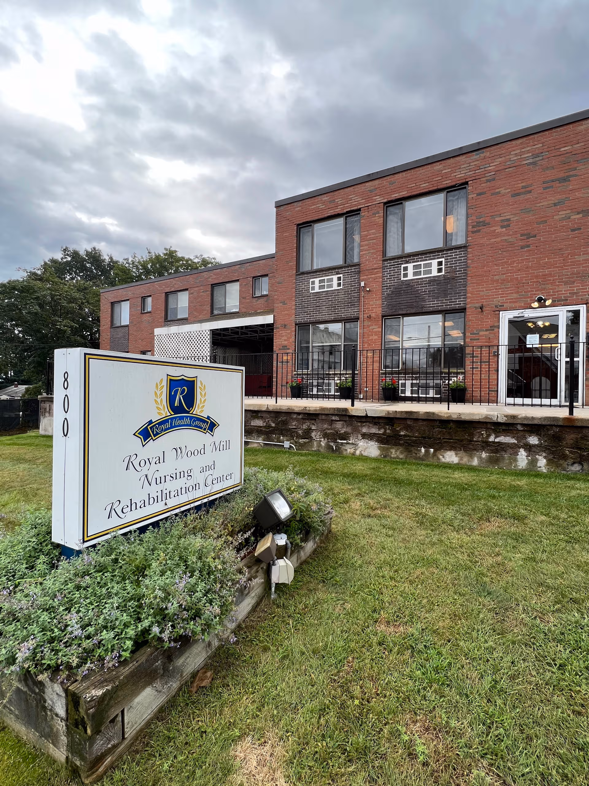 Brick nursing home building with front entrance and a large sign reading Royal Wood Mill.