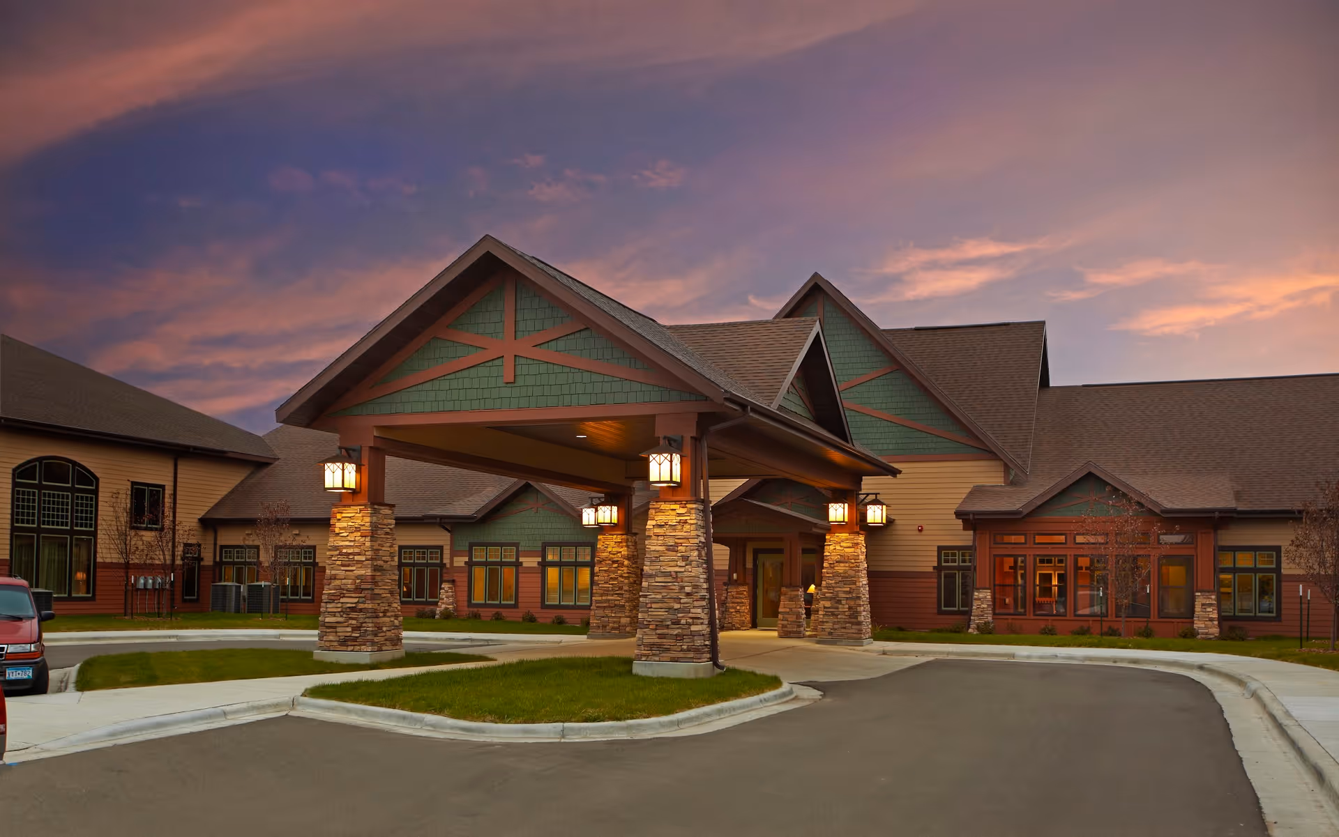 Exterior view of Warroad Senior Living Center with a covered entrance and stone pillars.