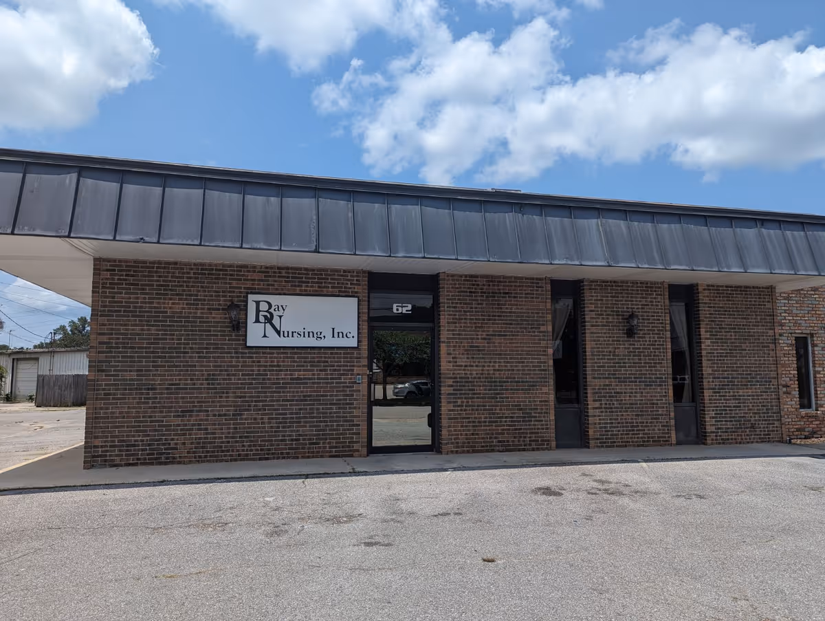 Brick building with a Bay Nursing, Inc. sign and entrance under a metal awning.