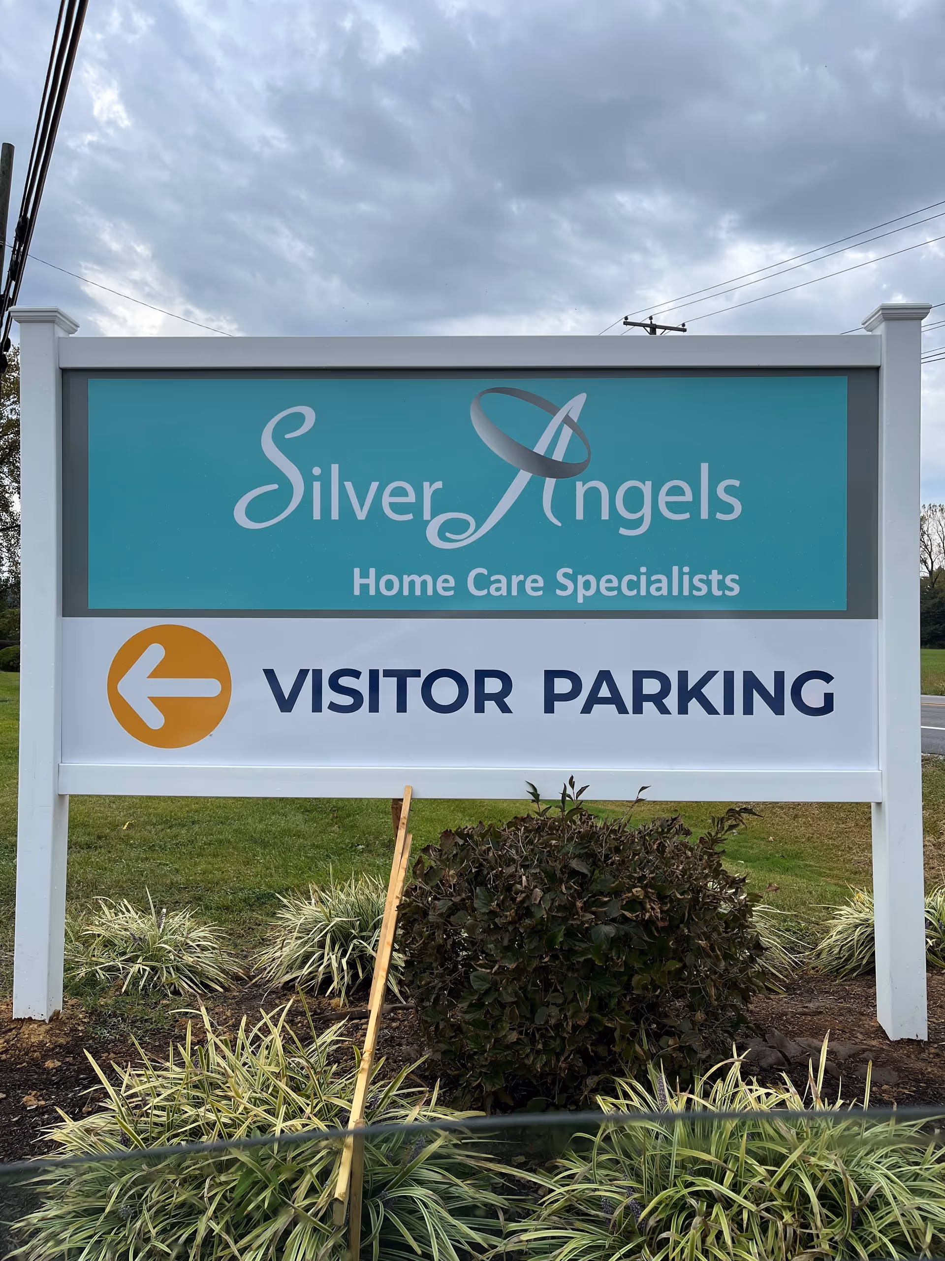Outdoor sign for Silver Angels Home Care Specialists, indicating visitor parking to the left.