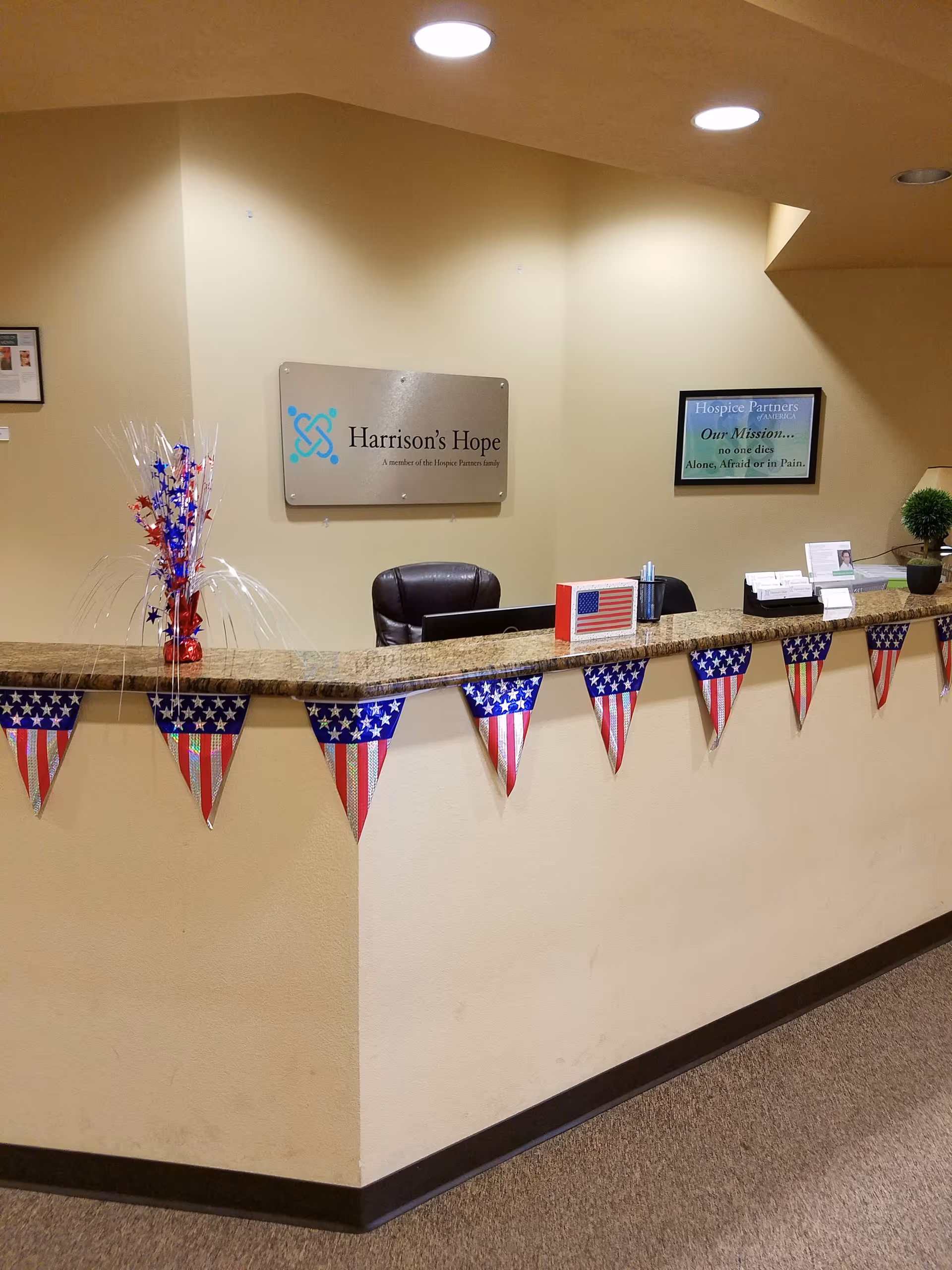 Interior reception desk at Harrison's Hope with patriotic bunting and a sign.