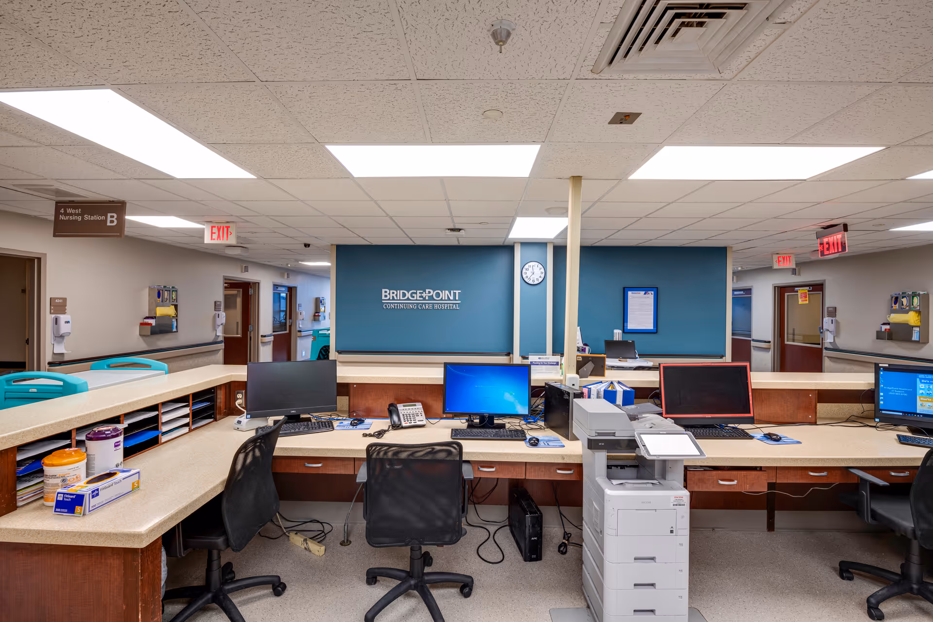 Interior hospital reception area with long counter, computers, printers, and a BridgePoint sign.