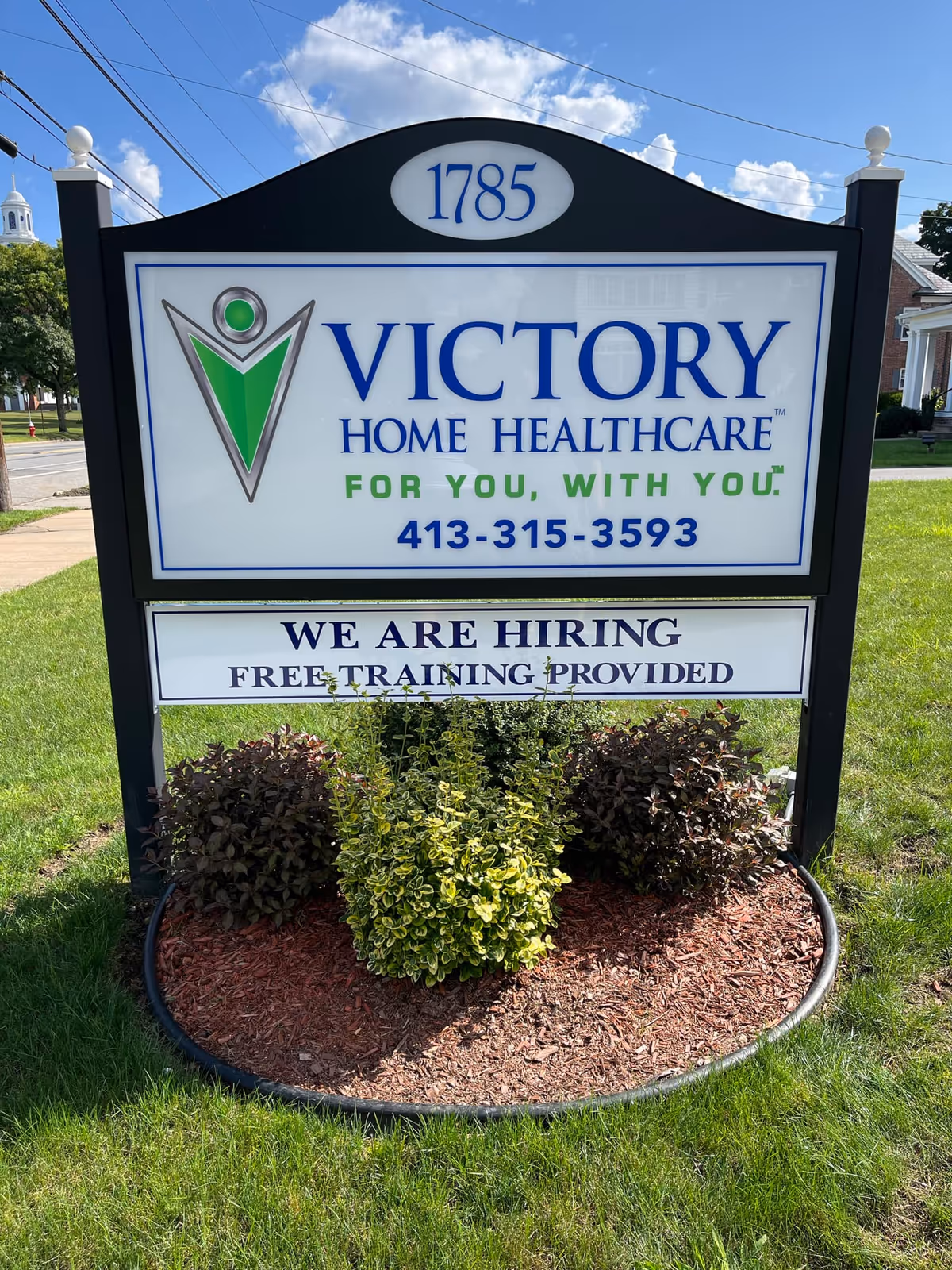 A freestanding outdoor sign for Victory Home Healthcare with landscaping at the base.