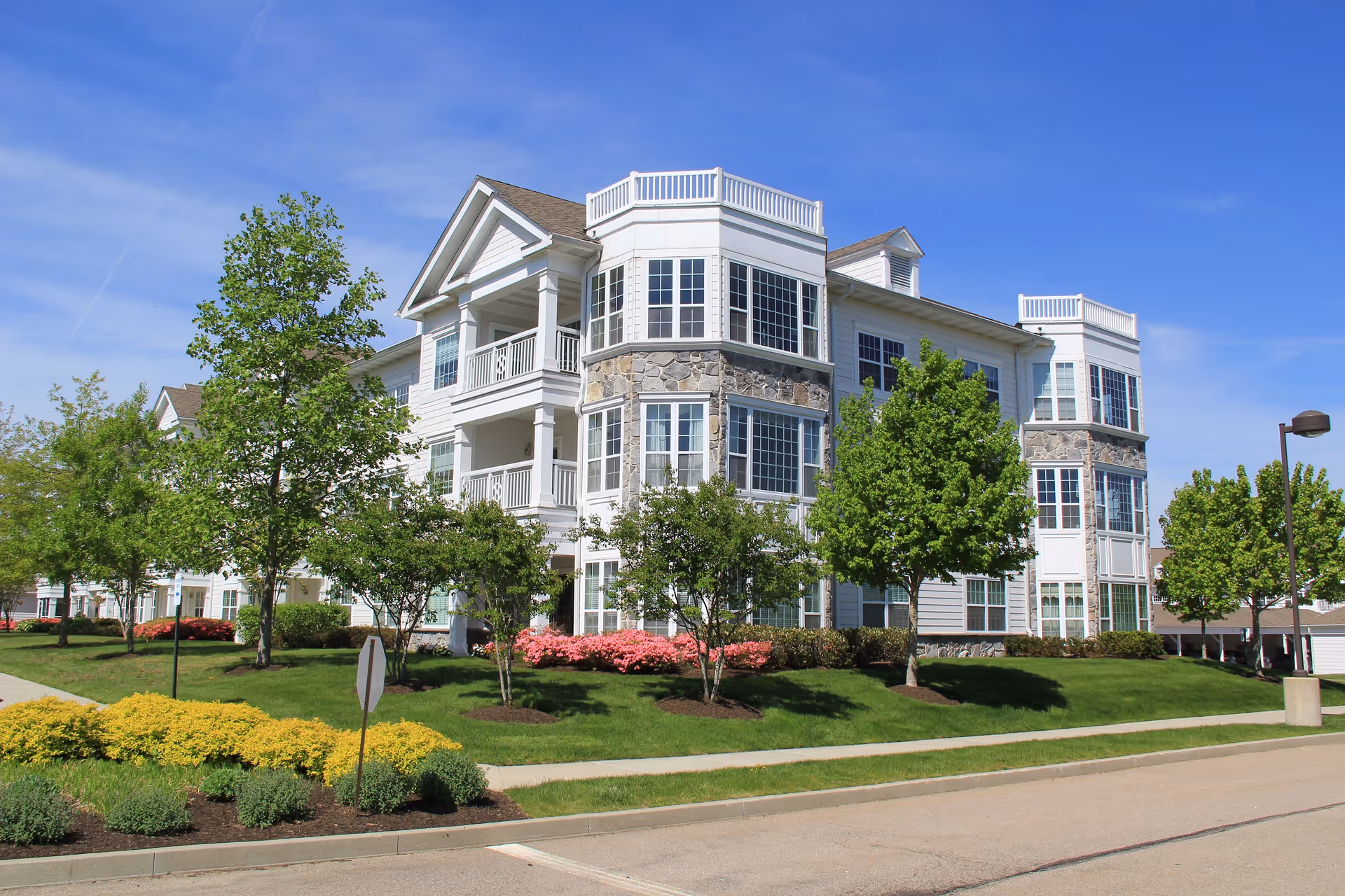 Front exterior of a StoneRidge Senior Living building with balconies and well-kept landscaping.