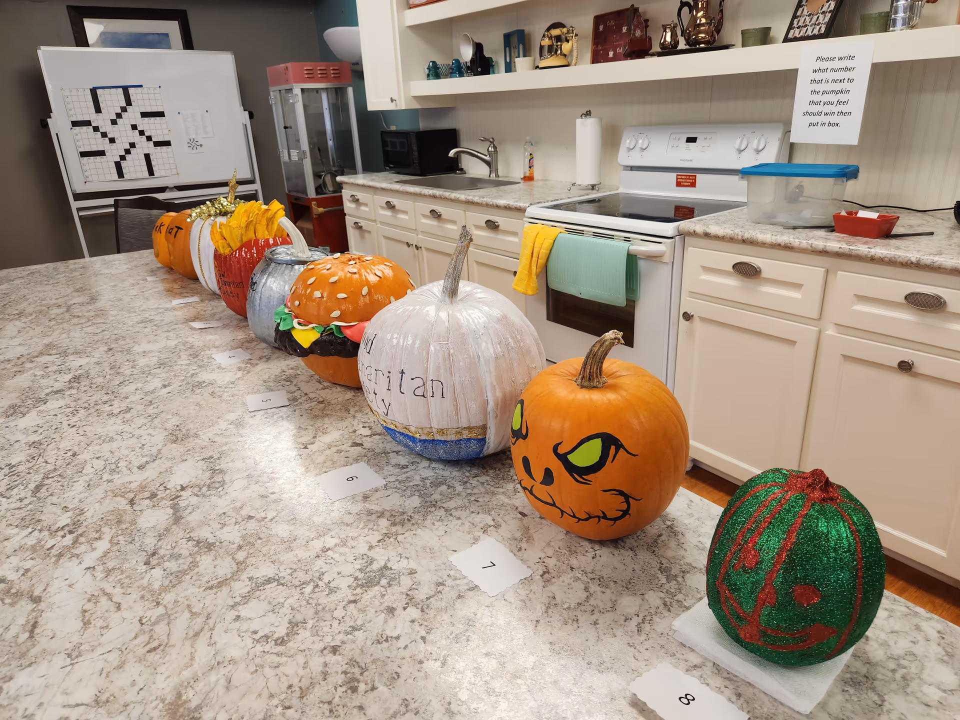 Decorated pumpkins line a kitchen island in a senior living facility.