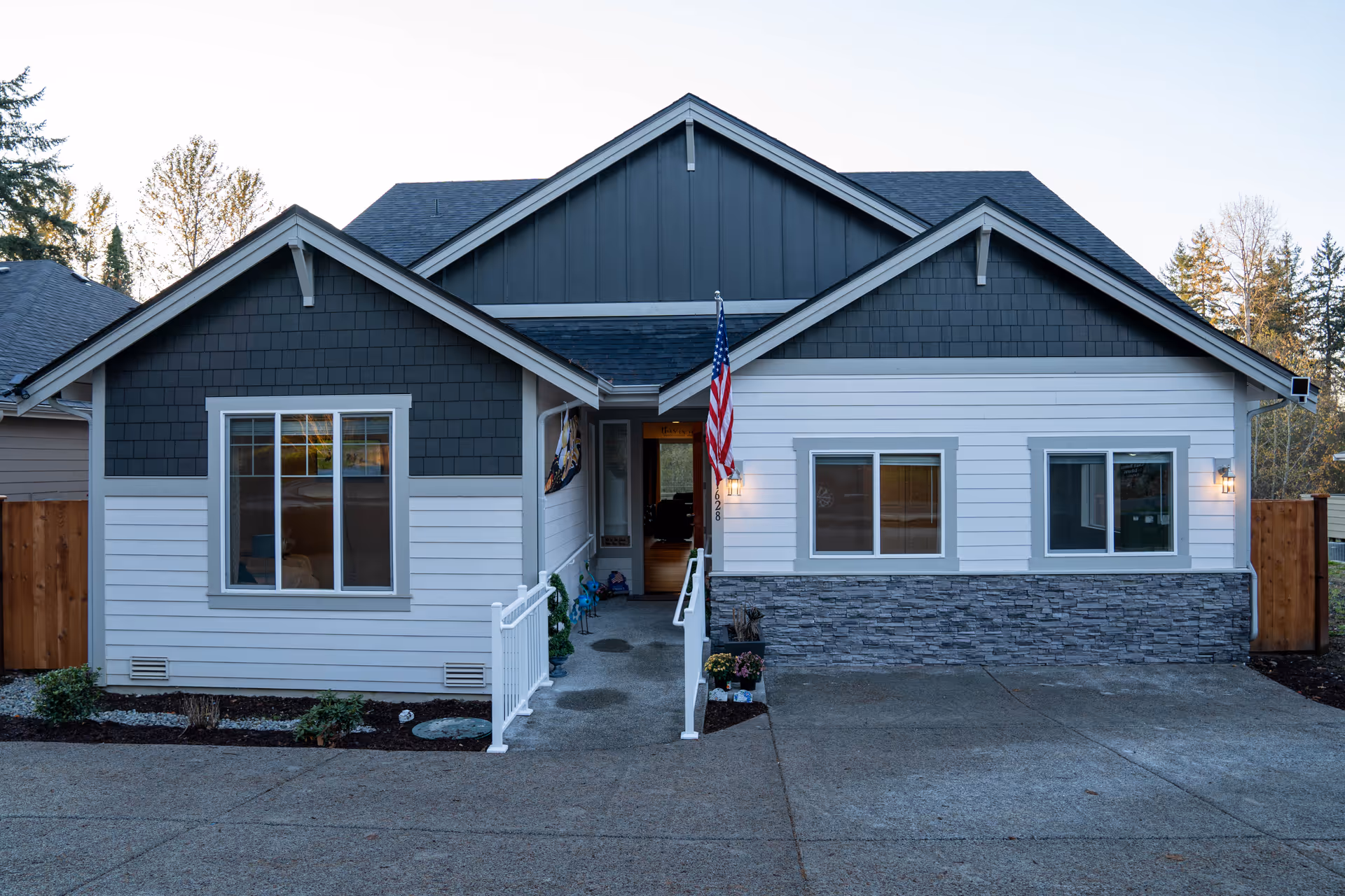 Front view of a single-story senior living facility with flag and entrance