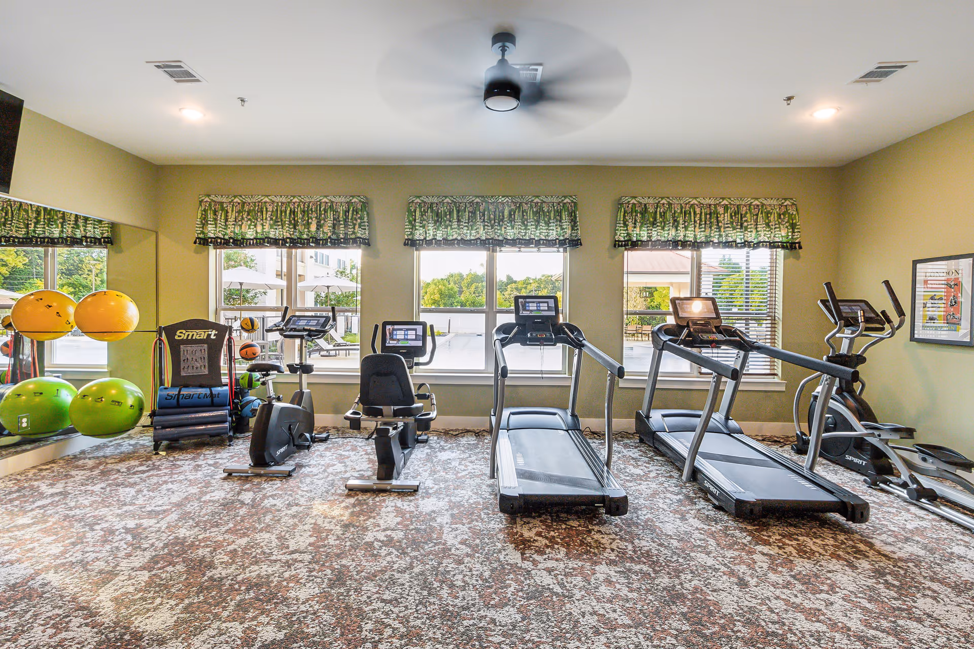 Indoor senior fitness room with treadmills, bikes, and exercise balls.