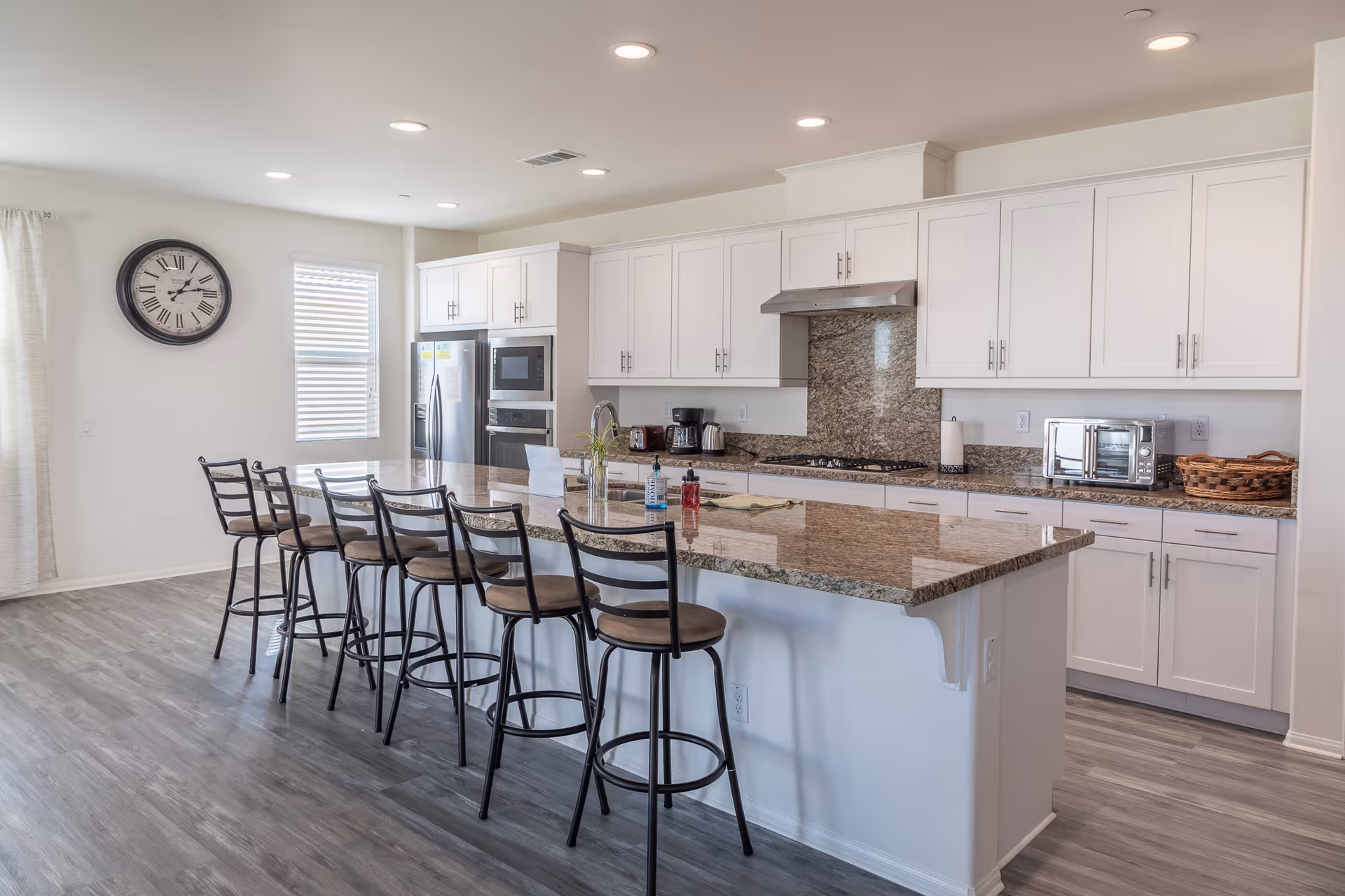 Bright, modern Mondell Pine Manor II kitchen with island, white cabinets, and bar stools.